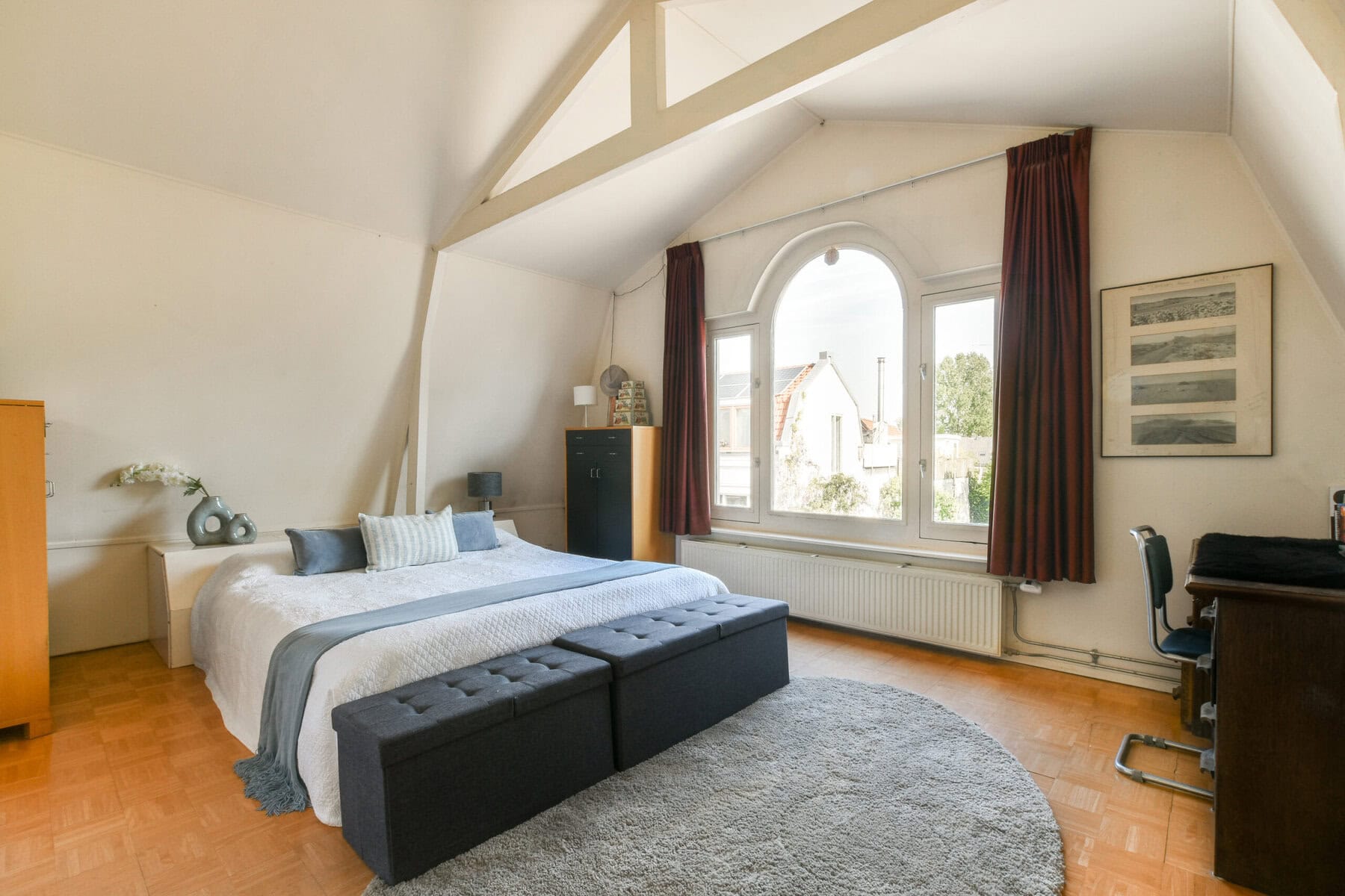 Ruime slaapkamer met grote ramen en comfortabele bedden.